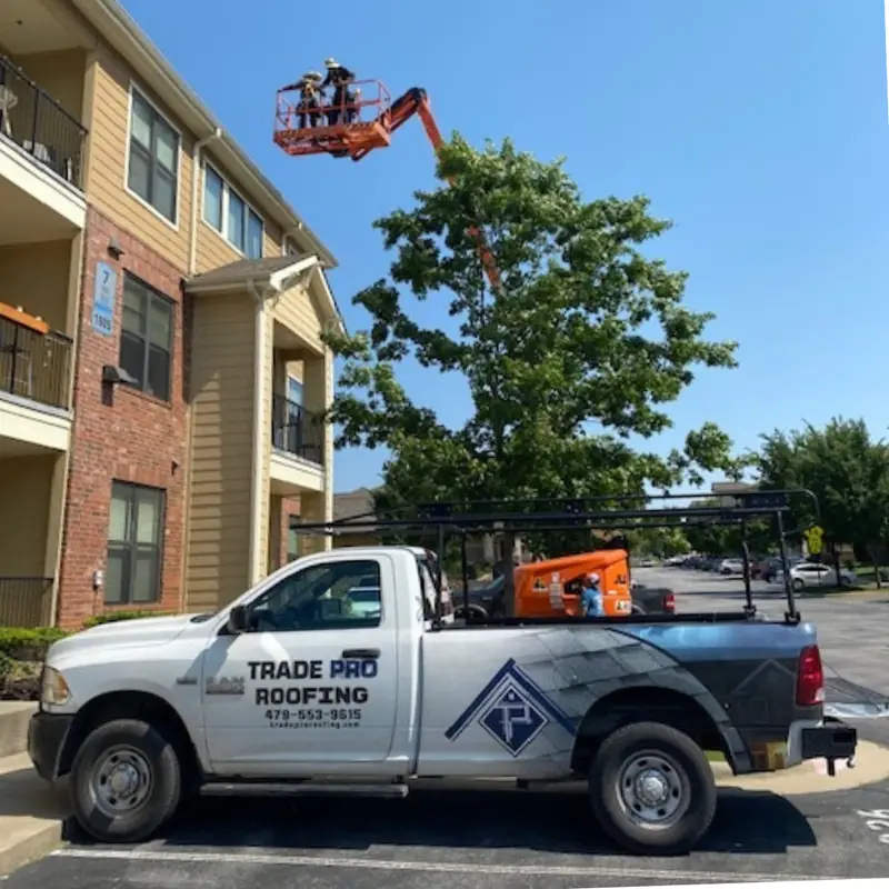 Trade Pro crew in a boom lift at the eaves of an apartment building