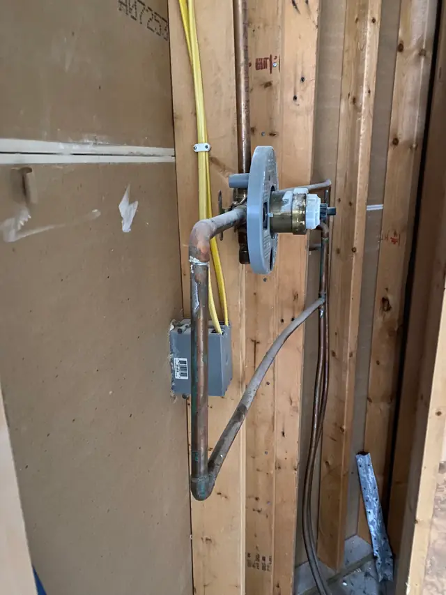Shower valve rough-in in open framing during an interior rebuild