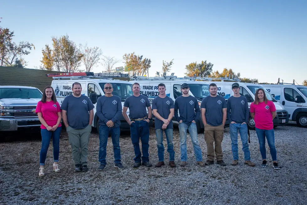 The Trade Pro crew in navy company shirts in front of their work vans